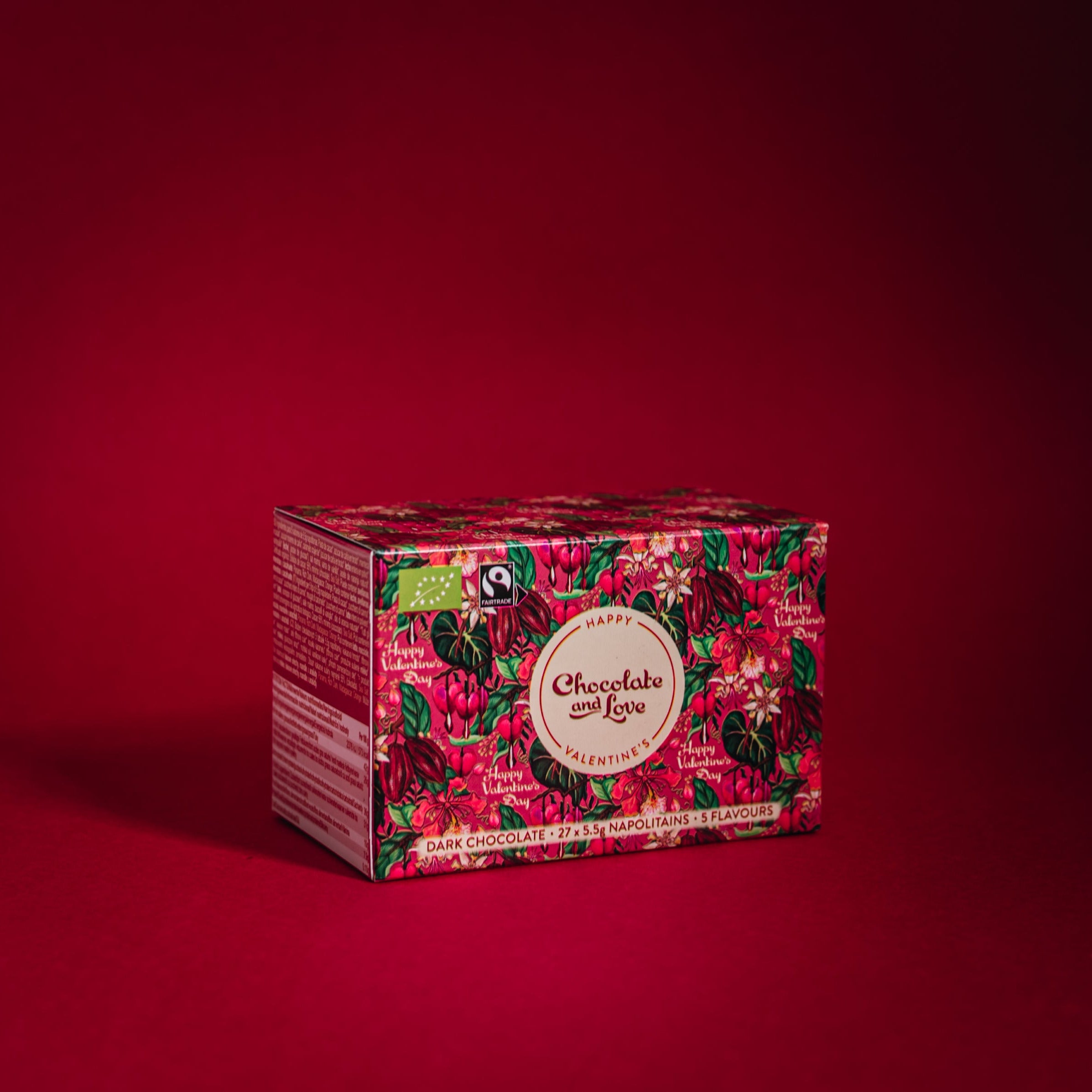 Valentines Nap Box (soft pinky red colour with hand painted leaves and Kakao pods and flowers) on red back ground with a shadow behind the box.